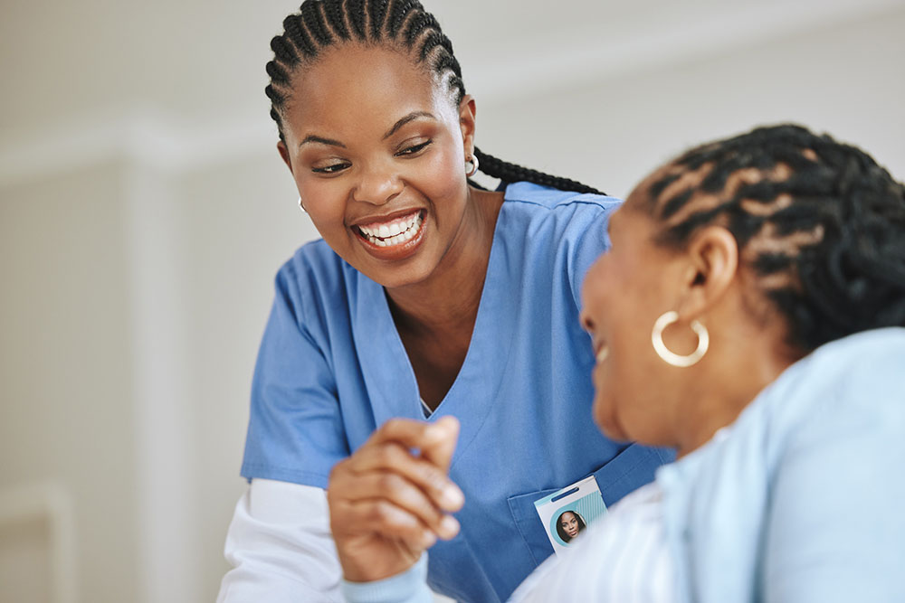 A nurse shares a smile and laugh with a patient